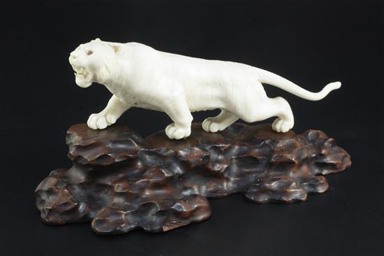 A Japanese ivory figure of a prowling tiger, signed Gyoku..? Meiji period, total length 23.5cm